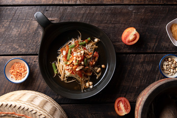 Som Tam Thai - Papaya Salad Thai Food Style on wooden tabal background. Thai Food Concept. Top View