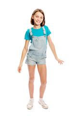 Teen girl in denim overalls in a flying pose, full height. Isolated on a white background. Vertical.