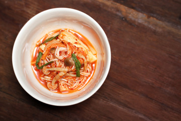 Spicy mushroom kimchi in a bowl on wooden background space copy Concept food
