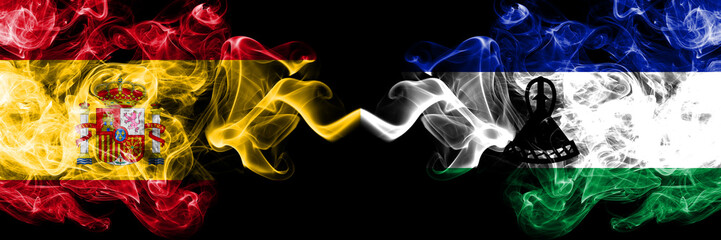 Spain vs Lesotho smoky mystic flags placed side by side. Thick colored silky smokes flag of Spanish...