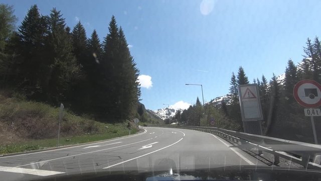 Driving a Car on Mountain Roads in Austria during summer in snow and sunshine