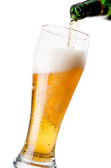 Pouring beer from bottle to glass on white background