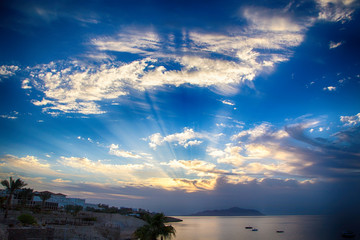 Sunrise over the red sea. Beautiful bright sky with sun rays and morning clouds. Sea and boats....