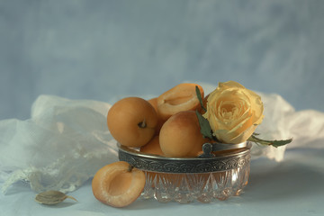 Still life with ripe apricots and roses