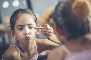 Beautiful girl, a ballet dancer Looking at the mirror and lipstick makeup behind the stage before starting acting