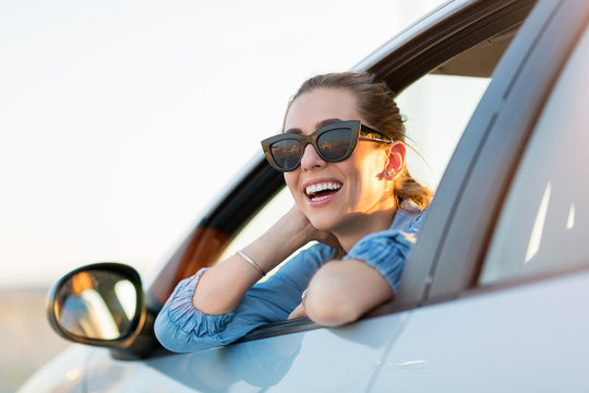 Happy woman driving a car and smiling