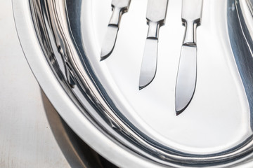 Closeup of surgical scalpels on stainless steel table with blood