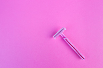 One women's razor pink on an isolated pink background.
