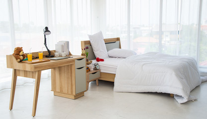 The modern or minimal interior bedroom design decorated with comfortable  double bed, white bedding such as blanklet, pillows and wooden furniture