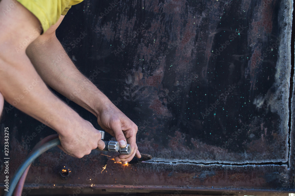 Wall mural worker cuts and brews black metal close-up shot