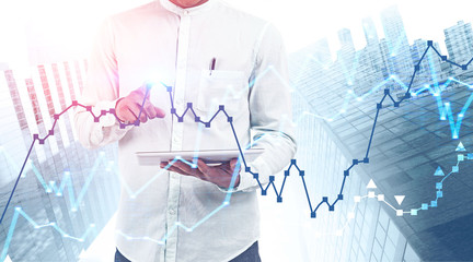 Man with tablet computer in city, digital graph
