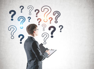 Businessman with clipboard and question marks