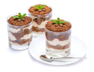 Classic tiramisu dessert in a glass on plate with spoon isolated on a white with clipping path