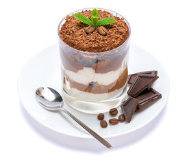 Classic tiramisu dessert in a glass on plate with spoon isolated on a white with clipping path