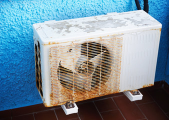 OLD  AIR CONDITIONER ON THE BLUE WALL
