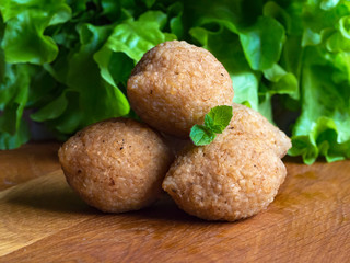 Arabic kibbeh with lamb and pine nuts on a wooden table. Close up