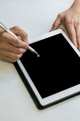 Hand writing digital pen on digital tablet on white table.