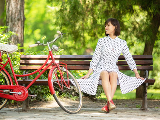 Beautiful young woman sitting on bench in park