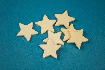 A bunch of wooden stars on a blue background chaotically scattered.