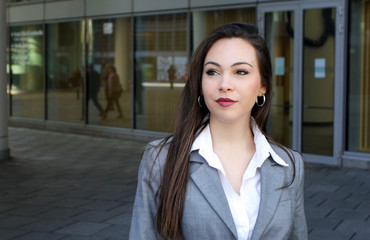 Confident young female manager walking outdoor in a modern urban setting