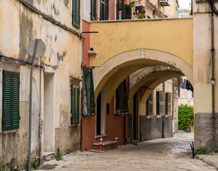 Fototapeta na wymiar Narrow street with arch between homes in Kerkyra