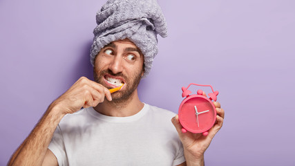 Hygiene, morning routine and teeth whitening concept. Busy man hurries after awakening, brushes...