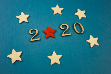 2020 number from wooden numbers on a blue background with scattered stars gears and flags around