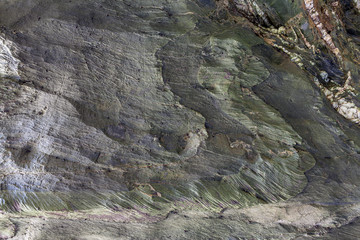 Superfície texturizada de rocha natural, onde se podem linhas desenhadas pelas camadas da rocha formadas ao longo do tempo. Pode ser usado como fundo.