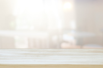 image of wooden table in front of abstract blurred window light background