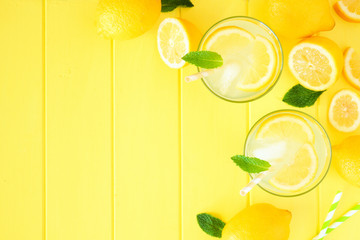 Sweet summer lemonade. Top view corner border with copy space on bright yellow wood background.
