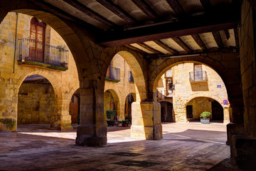 Fototapeta na wymiar Arches in a medieval square in Horta de Sant Joan