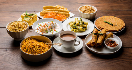 Group of Gujarati snacks like jalebi-fafda, thepla, khaman dhokla, aloo bhujiya, khandvi,khakra,...