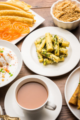 Group of Gujarati snacks like jalebi-fafda, thepla, khaman dhokla, aloo bhujiya, khandvi,khakra, dahi vada, gathiya with hot tea