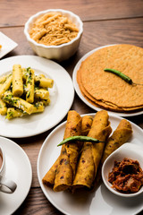 Group of Gujarati snacks like jalebi-fafda, thepla, khaman dhokla, aloo bhujiya, khandvi,khakra, dahi vada, gathiya with hot tea