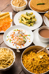 Group of Gujarati snacks like jalebi-fafda, thepla, khaman dhokla, aloo bhujiya, khandvi,khakra, dahi vada, gathiya with hot tea