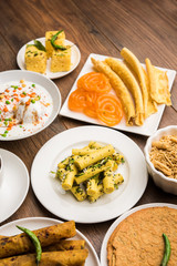 Group of Gujarati snacks like jalebi-fafda, thepla, khaman dhokla, aloo bhujiya, khandvi,khakra, dahi vada, gathiya with hot tea
