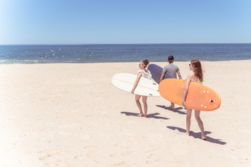 Fototapeta na wymiar Boys and girls teen surfers with surfboards