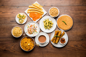Group of Gujarati snacks like jalebi-fafda, thepla, khaman dhokla, aloo bhujiya, khandvi,khakra, dahi vada, gathiya with hot tea