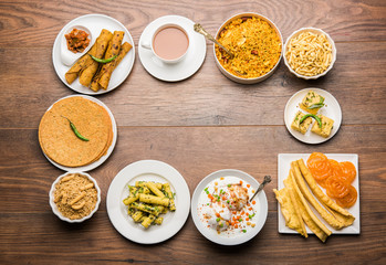 Group of Gujarati snacks like jalebi-fafda, thepla, khaman dhokla, aloo bhujiya, khandvi,khakra, dahi vada, gathiya with hot tea