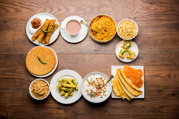 Group of Gujarati snacks like jalebi-fafda, thepla, khaman dhokla, aloo bhujiya, khandvi,khakra, dahi vada, gathiya with hot tea