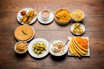 Group of Gujarati snacks like jalebi-fafda, thepla, khaman dhokla, aloo bhujiya, khandvi,khakra, dahi vada, gathiya with hot tea