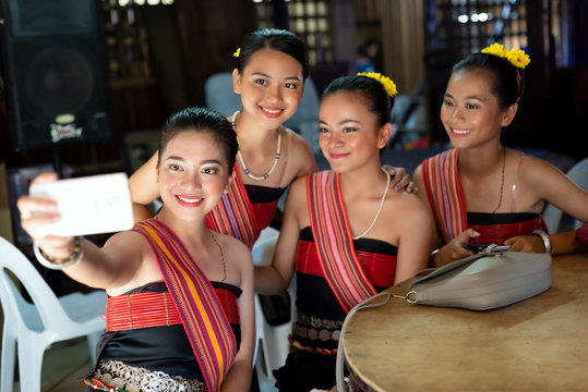 Group portrait of Kadazan Dusun young girls in traditional attire taking selfie with smart phone during state level Harvest Festival in KDCA, Kota Kinabalu, Sabah Malaysia.