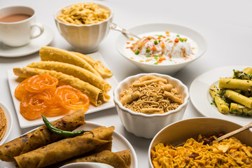 Group of Gujarati snacks like jalebi-fafda, thepla, khaman dhokla, aloo bhujiya, khandvi,khakra, dahi vada, gathiya with hot tea