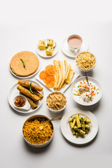 Group of Gujarati snacks like jalebi-fafda, thepla, khaman dhokla, aloo bhujiya, khandvi,khakra, dahi vada, gathiya with hot tea
