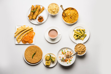 Group of Gujarati snacks like jalebi-fafda, thepla, khaman dhokla, aloo bhujiya, khandvi,khakra, dahi vada, gathiya with hot tea