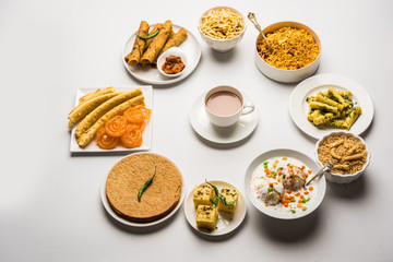 Group of Gujarati snacks like jalebi-fafda, thepla, khaman dhokla, aloo bhujiya, khandvi,khakra, dahi vada, gathiya with hot tea