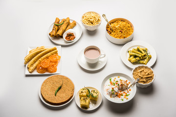 Group of Gujarati snacks like jalebi-fafda, thepla, khaman dhokla, aloo bhujiya, khandvi,khakra, dahi vada, gathiya with hot tea