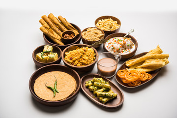 Group of Gujarati snacks like jalebi-fafda, thepla, khaman dhokla, aloo bhujiya, khandvi,khakra, dahi vada, gathiya with hot tea