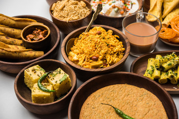 Group of Gujarati snacks like jalebi-fafda, thepla, khaman dhokla, aloo bhujiya, khandvi,khakra, dahi vada, gathiya with hot tea