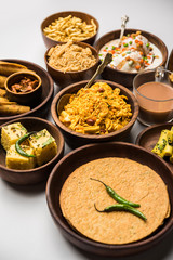 Group of Gujarati snacks like jalebi-fafda, thepla, khaman dhokla, aloo bhujiya, khandvi,khakra, dahi vada, gathiya with hot tea